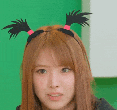 a close up of a woman wearing a headband with black feathers on it