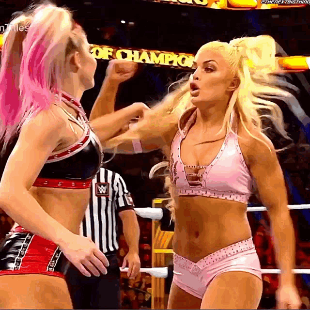 two women wrestling in front of a sign that says ' champions '
