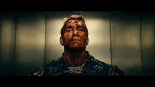 a man with blood on his face is looking up at the camera