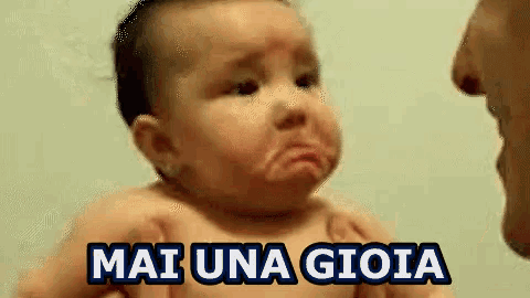 a baby is crying with the words mai una gioia written on it .