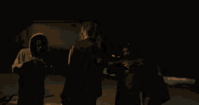 a man with dreadlocks is standing in a dark room with other men