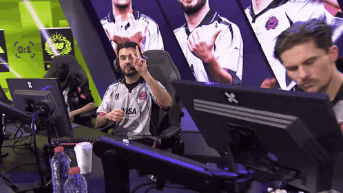 a man wearing a usa jersey sitting in front of a computer monitor
