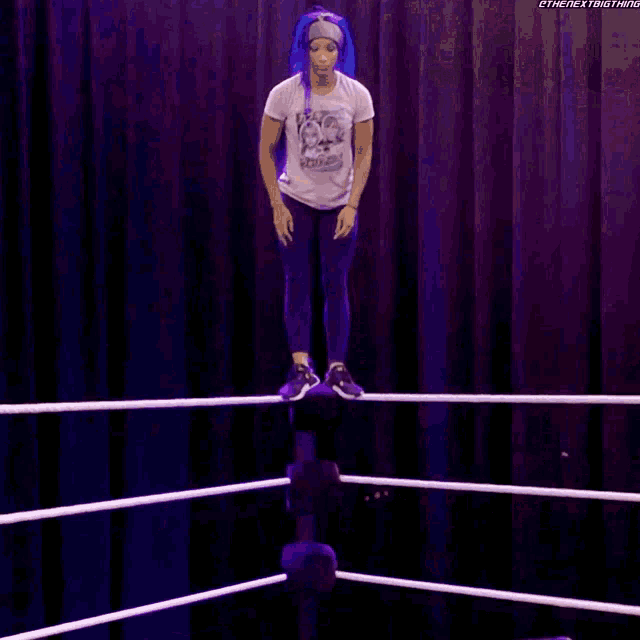 a wrestler is falling through the ropes in a wrestling ring
