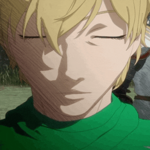 a man with blonde hair is wearing a green shirt and his eyes are closed