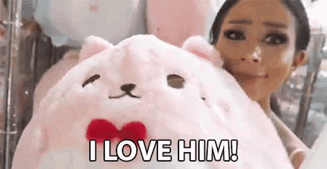 a woman is holding a stuffed animal that looks like a cat with a bow tie .