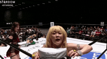 a woman in a wrestling ring with the word stardom on the bottom left