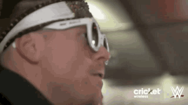 a man wearing sunglasses and a headband with a cricket wireless logo on it