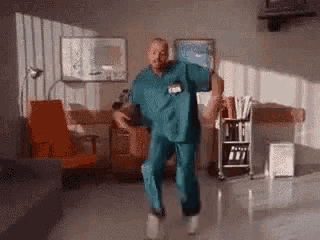 a man in a scrub is dancing in a room .