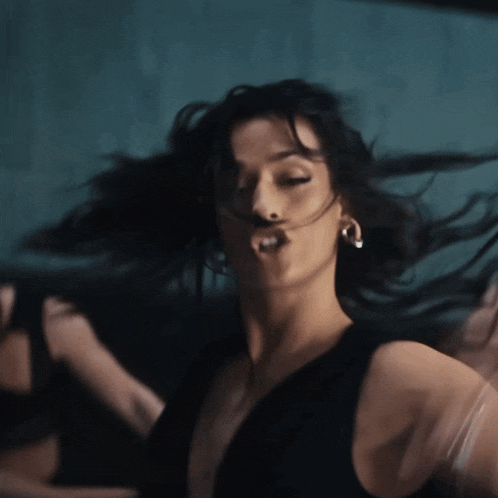 a woman in a black dress is making a face