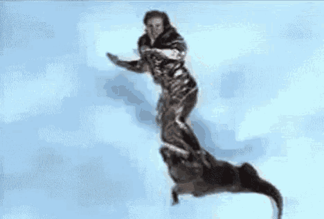 a man in a black and silver superhero costume is flying through the air .