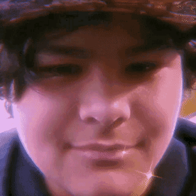 a close up of a person 's face with a hat