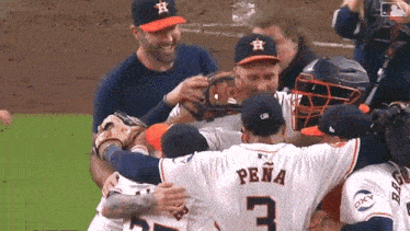 a baseball player with the number 3 on his back is hugging his teammates .