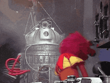 a pink stuffed animal is standing in front of a robot