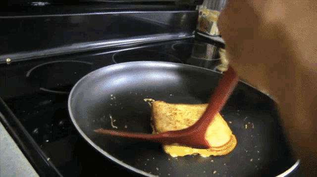 a person is cooking french toast in a pan
