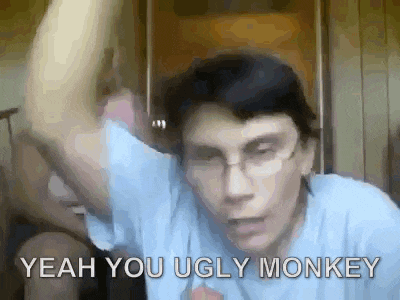 a man wearing glasses and a blue shirt is making a funny face and says yeah you ugly monkey .