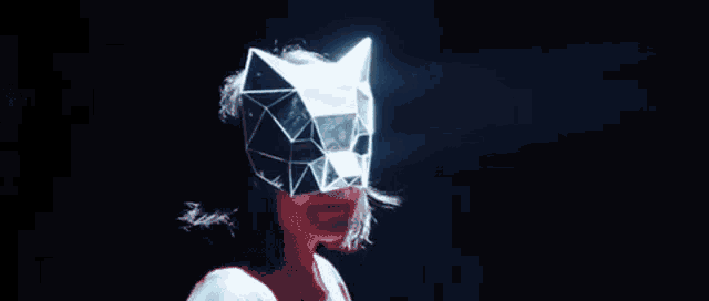 a woman wearing a cat mask with a light coming out of it in the dark .