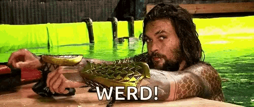 a man with a beard is laying in a swimming pool with the word werd written on the bottom .