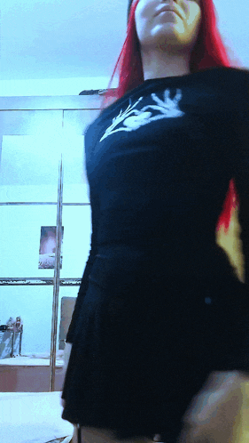 a woman with red hair is wearing a black shirt with a white flower on it
