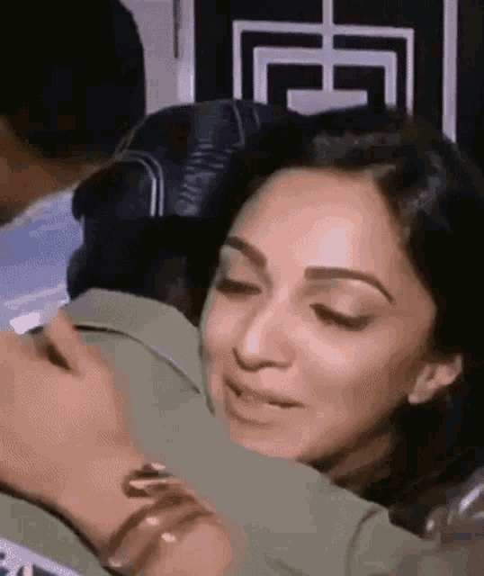 a close up of a woman hugging a man in a crowd .
