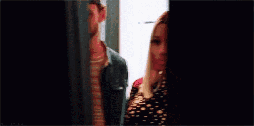 a woman is standing in front of a mirror wearing a black and white polka dot dress .