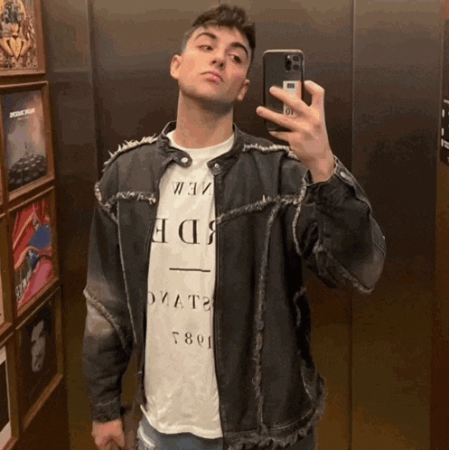 a man taking a picture of himself in an elevator while wearing a t-shirt that says " ovata "