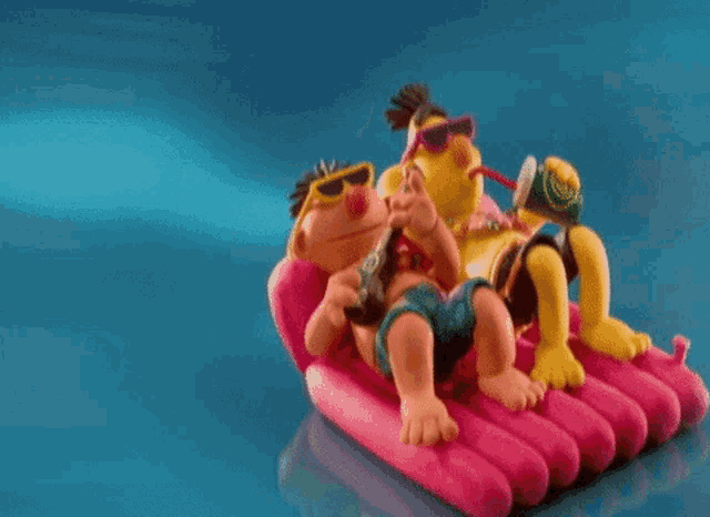 a couple of cartoon characters are laying on a pink raft