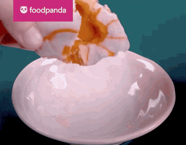 a person is dipping a piece of food into a bowl with a foodpanda logo above it