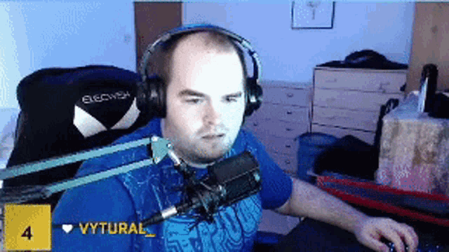 a man wearing headphones is sitting in front of a microphone with the number 4 on the bottom