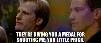 two men are sitting next to each other and one of them says they 're giving you a medal for shooting me .