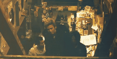 a group of people are standing in a dark room with a sign that says ' a ' on it