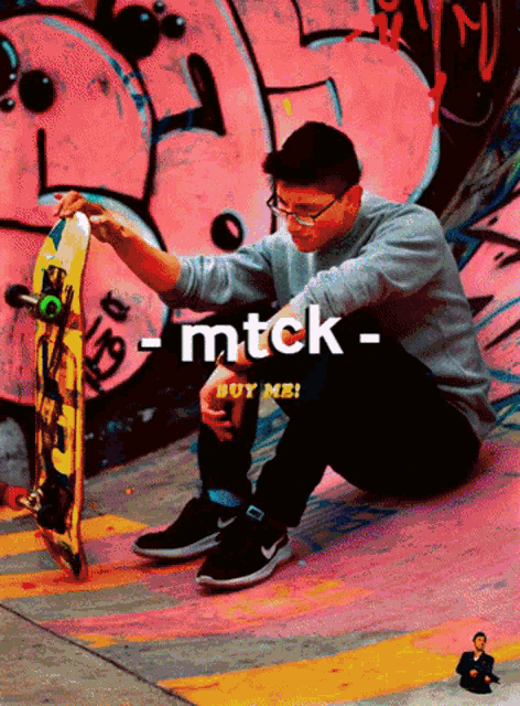 a man sitting on the ground with a skateboard in front of a wall that has the word mtck on it