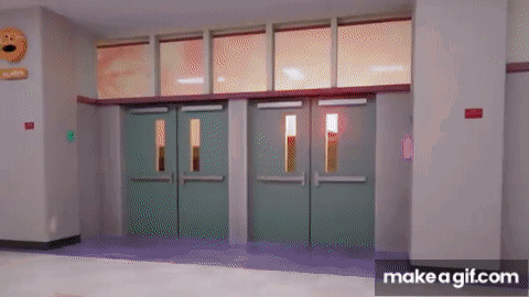a hallway with green doors and a sign that says ' emergency exit '