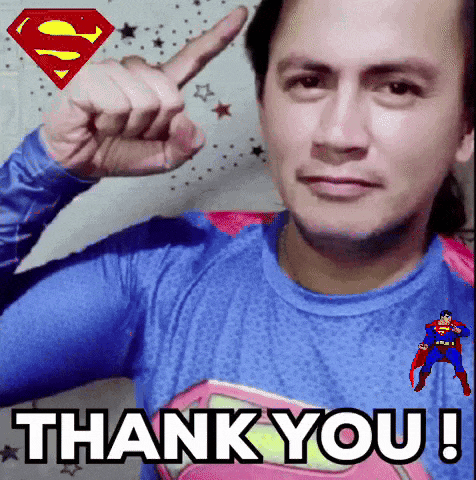 a man is wearing a superman shirt and giving a thank you gesture