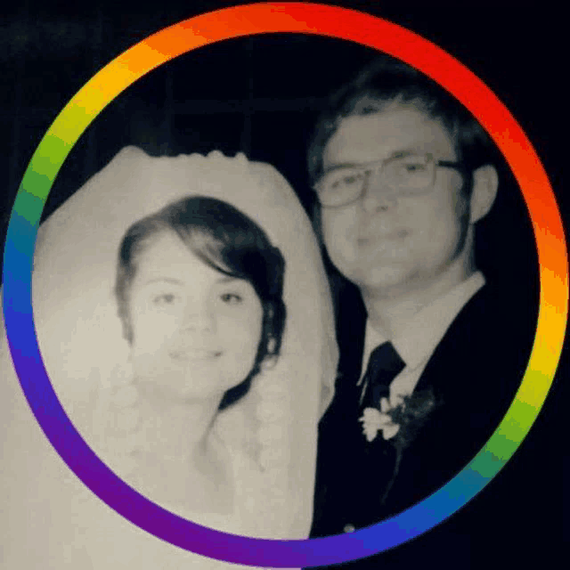 a black and white photo of a bride and groom surrounded by a rainbow colored circle