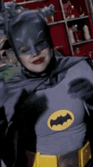 a woman dressed in a batman costume with a yellow bat on her chest