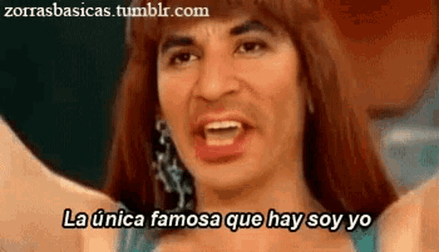 a woman in a wig is making a funny face and says la unica famosa que hay soy yo .