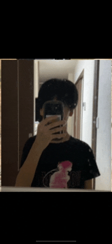 a person taking a picture of themselves in a mirror wearing a black shirt that says tokyo boy