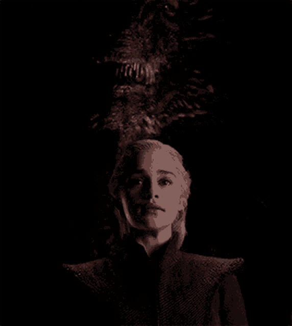 a woman is standing in front of a dragon with its mouth open .