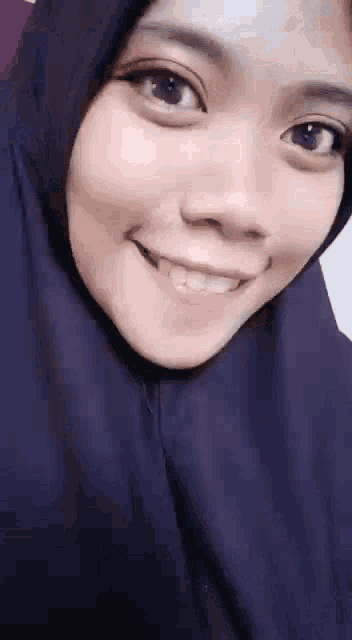 a close up of a woman wearing a hijab smiling .
