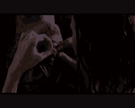 a close up of a person 's hand holding something in a dark room