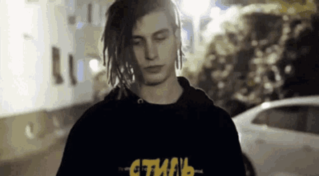 a young man with dreadlocks is wearing a black hoodie that says " gtman " on it