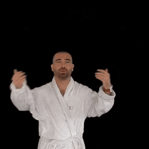 a man in a bathrobe is giving a thumbs up in front of a sun
