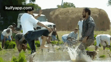 a man is kicking another man in the stomach in a field .