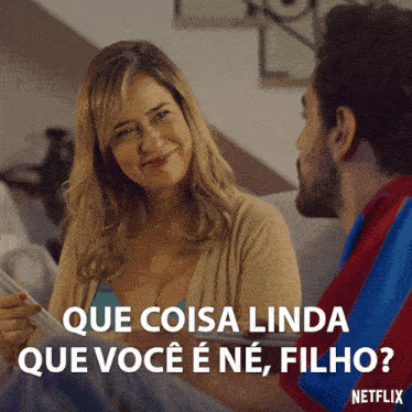 a man and a woman are sitting on a couch and the woman says que coisa linda que você e ne filho
