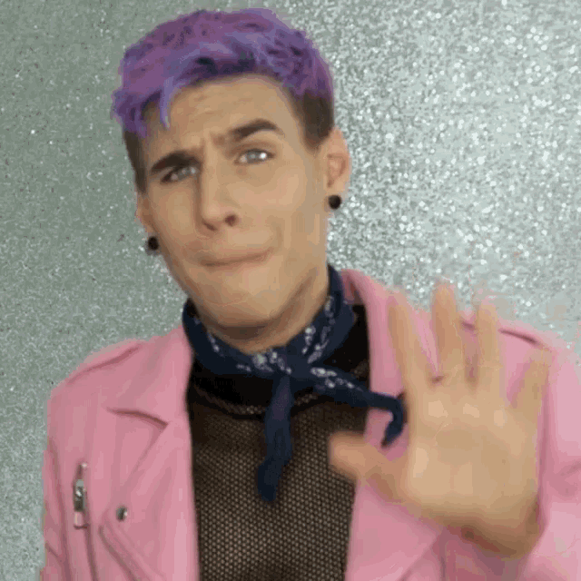 a man with purple hair is wearing a pink jacket and a bandana .