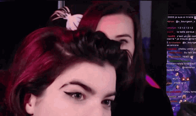 a woman with red hair is looking at another woman 's face