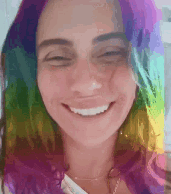 a close up of a woman 's face with rainbow hair