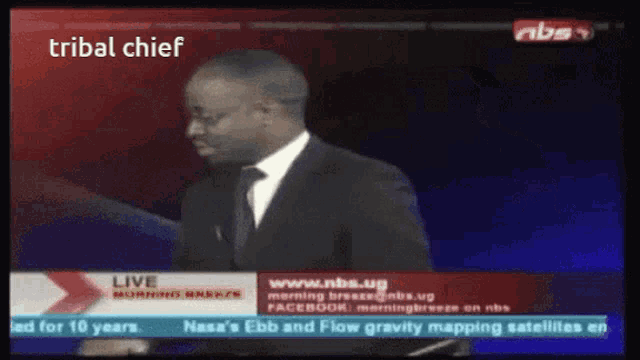 a tv screen shows a man in a suit and tie and the words tribal chief at the top