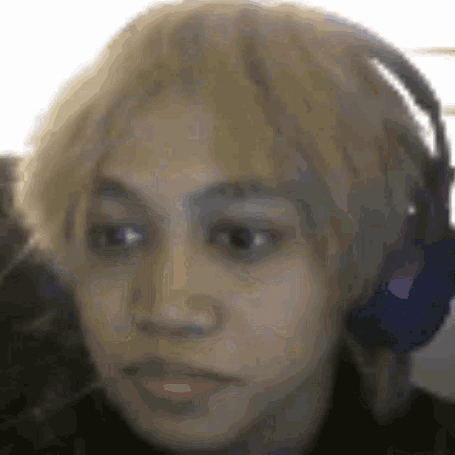 a close up of a person 's face with headphones on .
