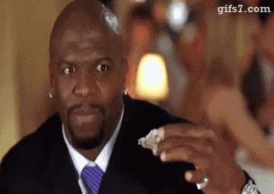 a man in a suit and tie is eating a piece of oysters .